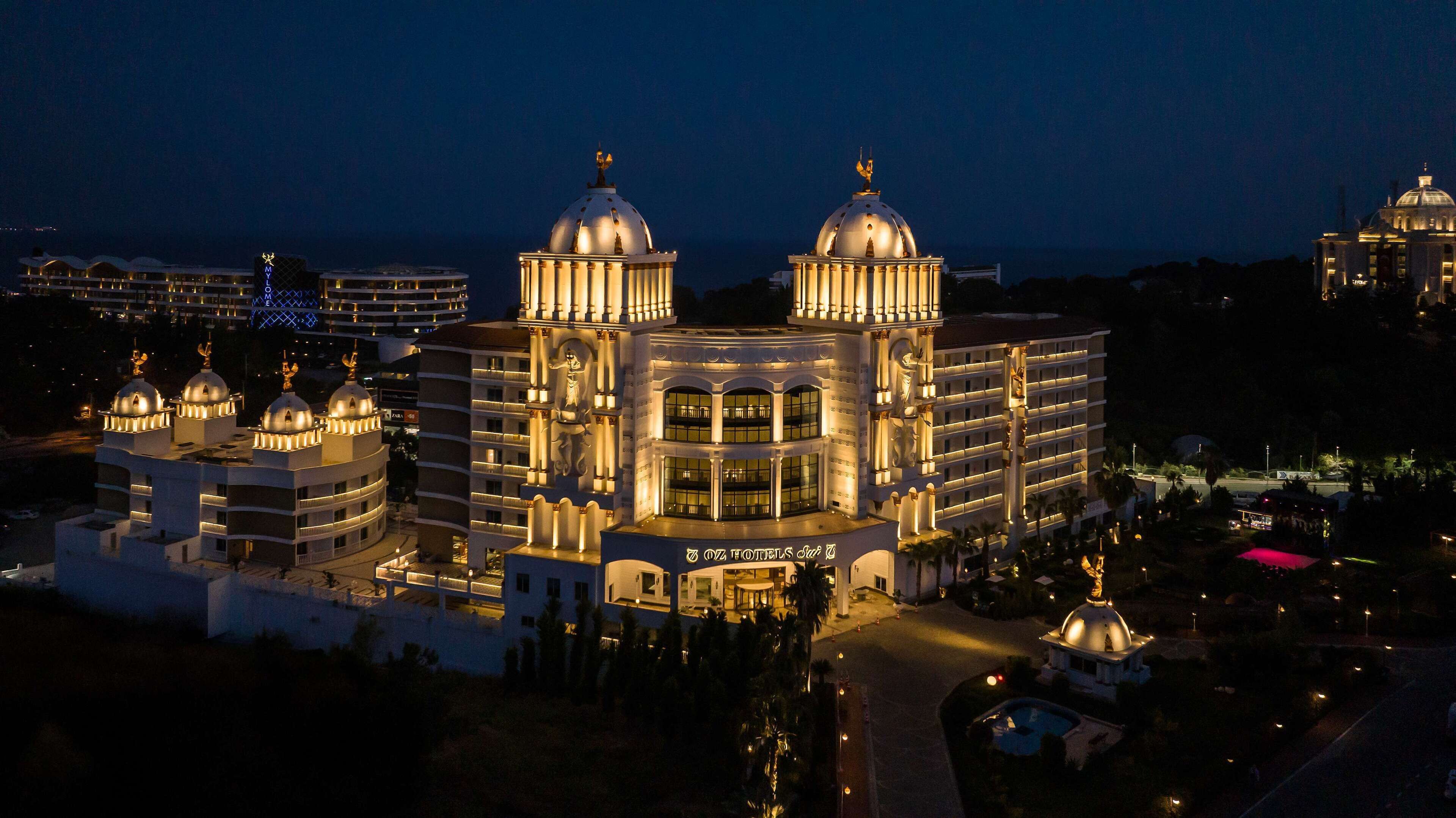 A large, multi-story hotel with a central dome and two smaller domes on either side.