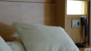 Un lit avec une couverture à motifs floraux et un oreiller blanc.