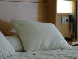 A bed with a floral-patterned blanket and a white pillow.