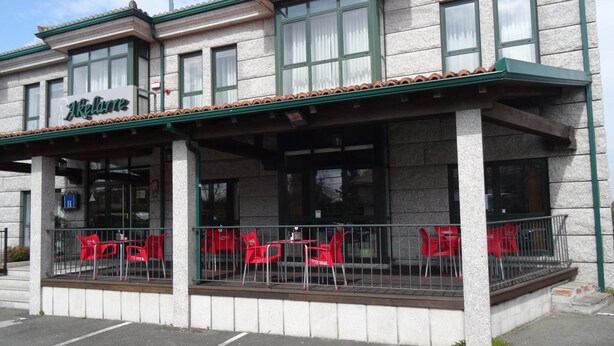 Il s’agit d’un bâtiment sur lequel on peut lire l’inscription « Akaflieg ». Il dispose d’un espace extérieur abrité avec des chaises et des tables rouges.