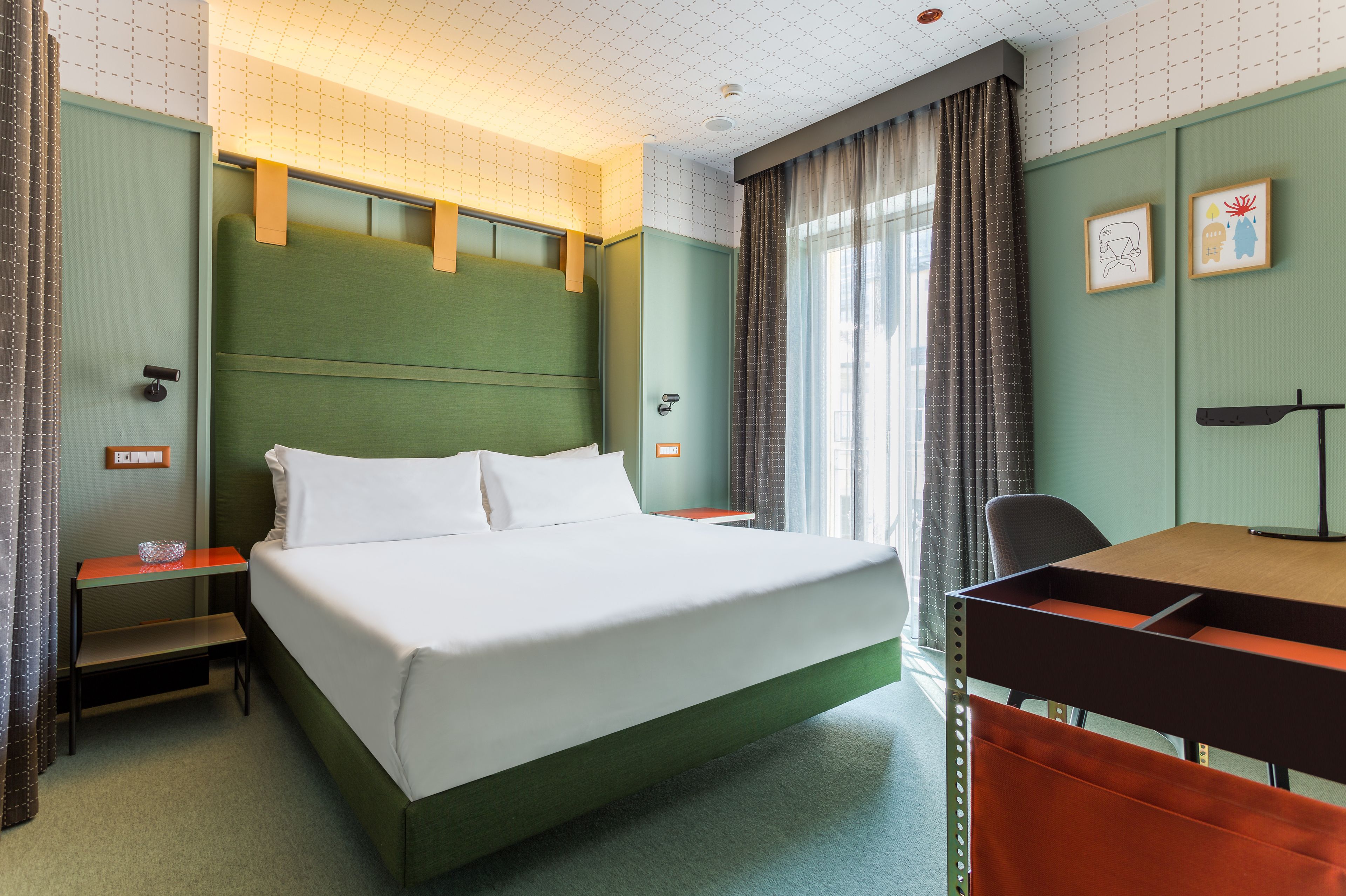Ein Hotelzimmer mit Bett, Schreibtisch und Stuhl.