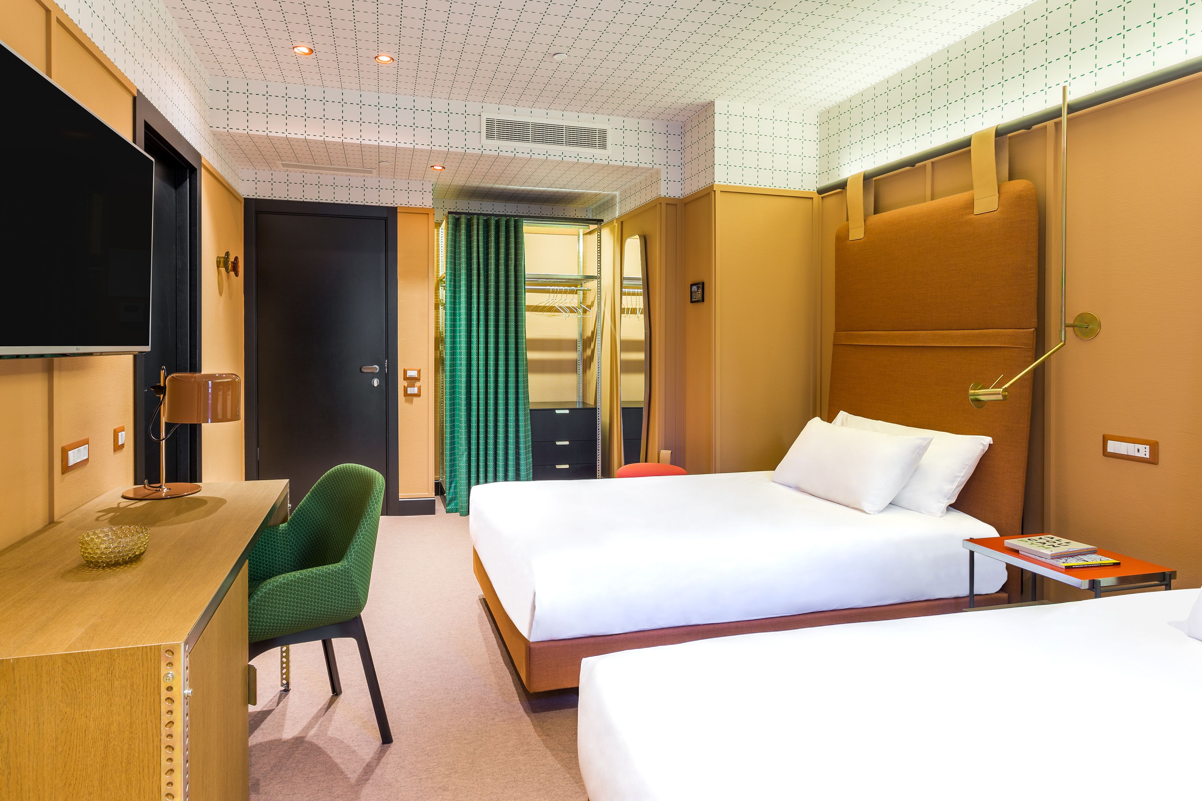 Una habitación de hotel con cama, escritorio, silla y televisión.