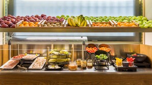 A buffet with various fruits, vegetables, and prepared dishes.