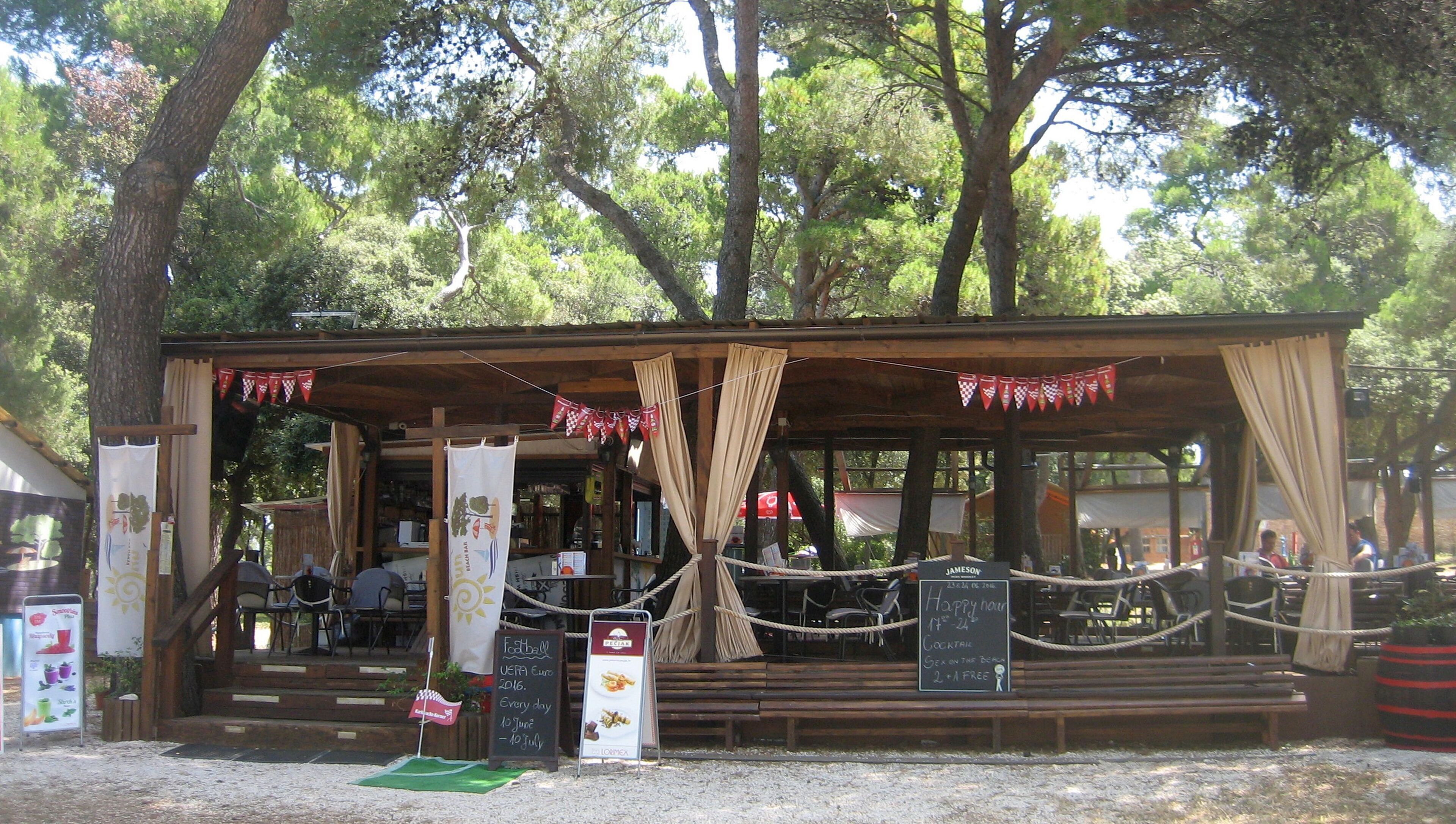 Un'area relax esterna in stile rustico, con struttura in legno, corde e festoni.