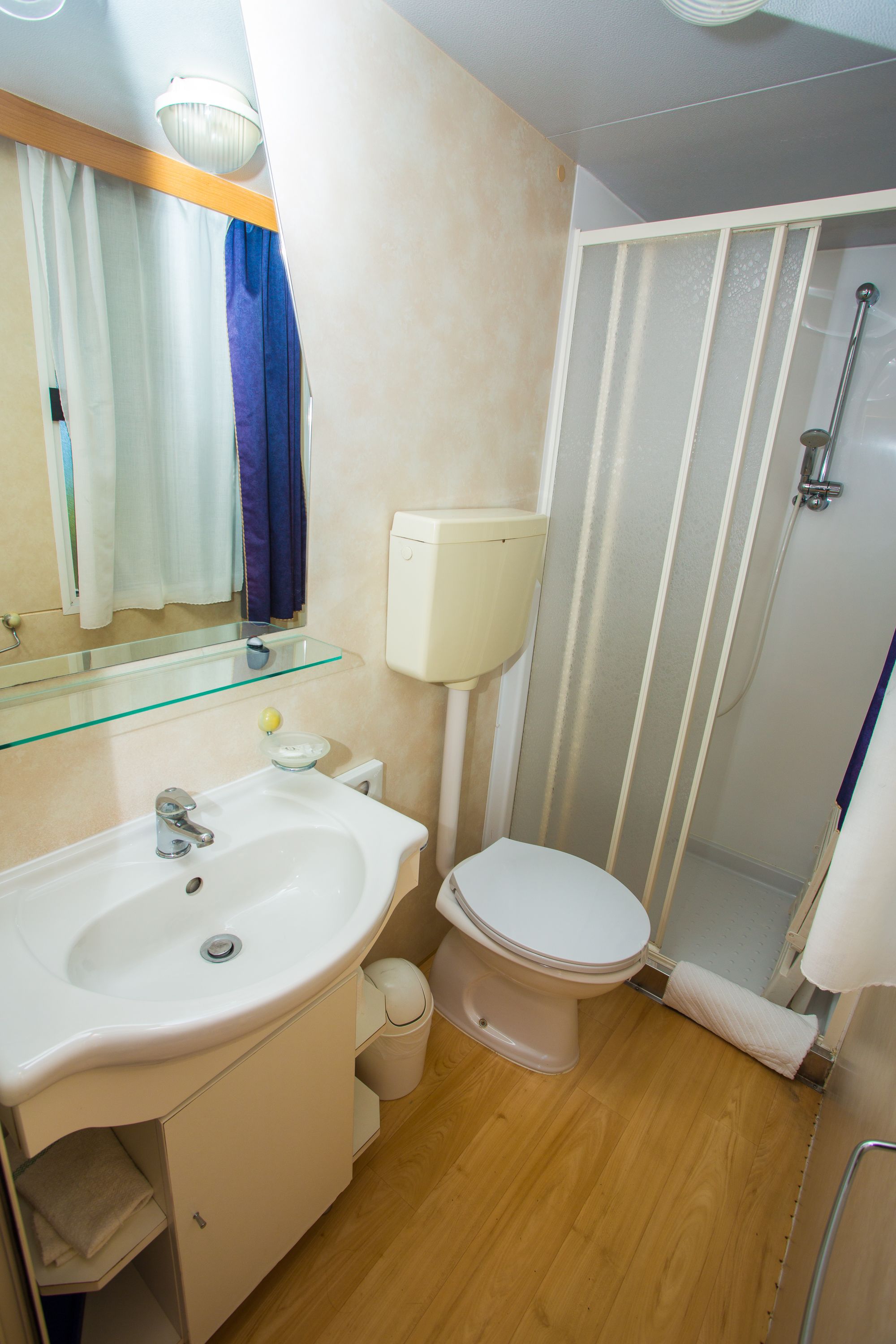 Un baño con lavamanos, inodoro y ducha.