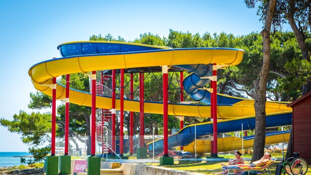 A water park with multiple slides and a beach area with sun loungers. - Arena Medulin Mobile Homes (Medulin)