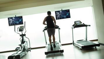 Un gimnasio con cintas de correr y una máquina elíptica.