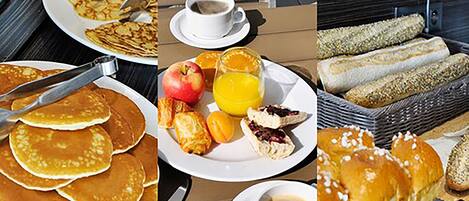 Un bufé de desayuno con panqueques, pasteles, frutas y bebidas.