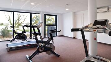A gym with treadmills, stationary bikes, and a rowing machine.