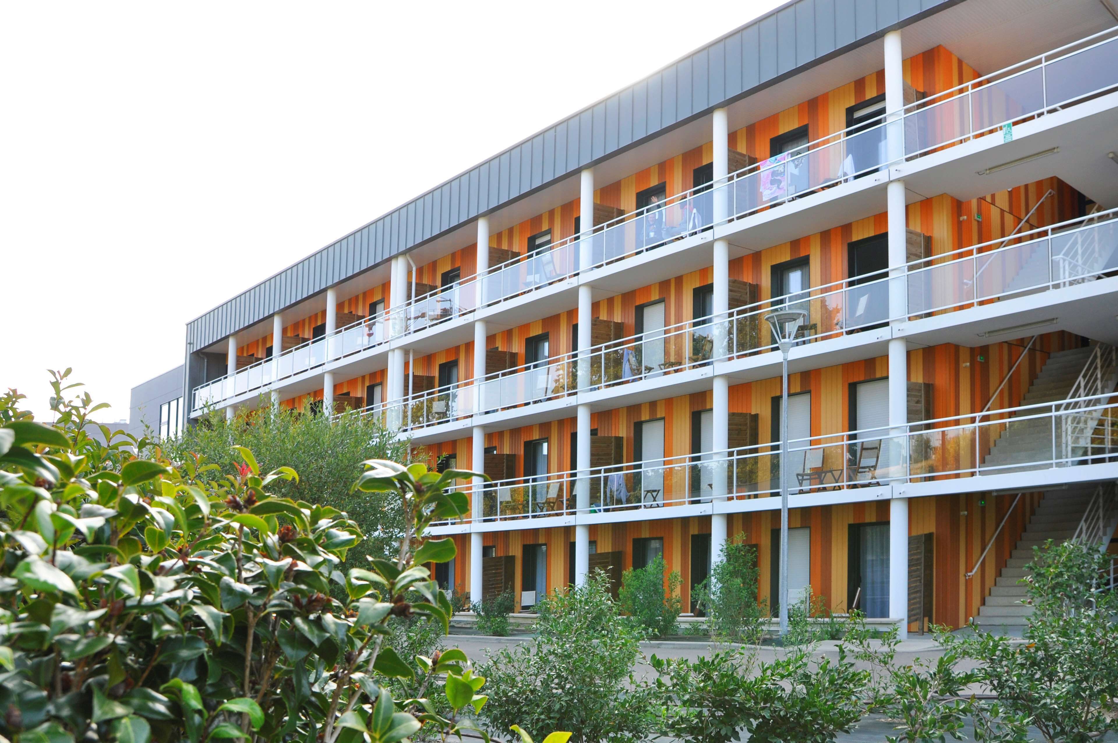 Un edificio de varios pisos con balcones y un diseño arquitectónico moderno.