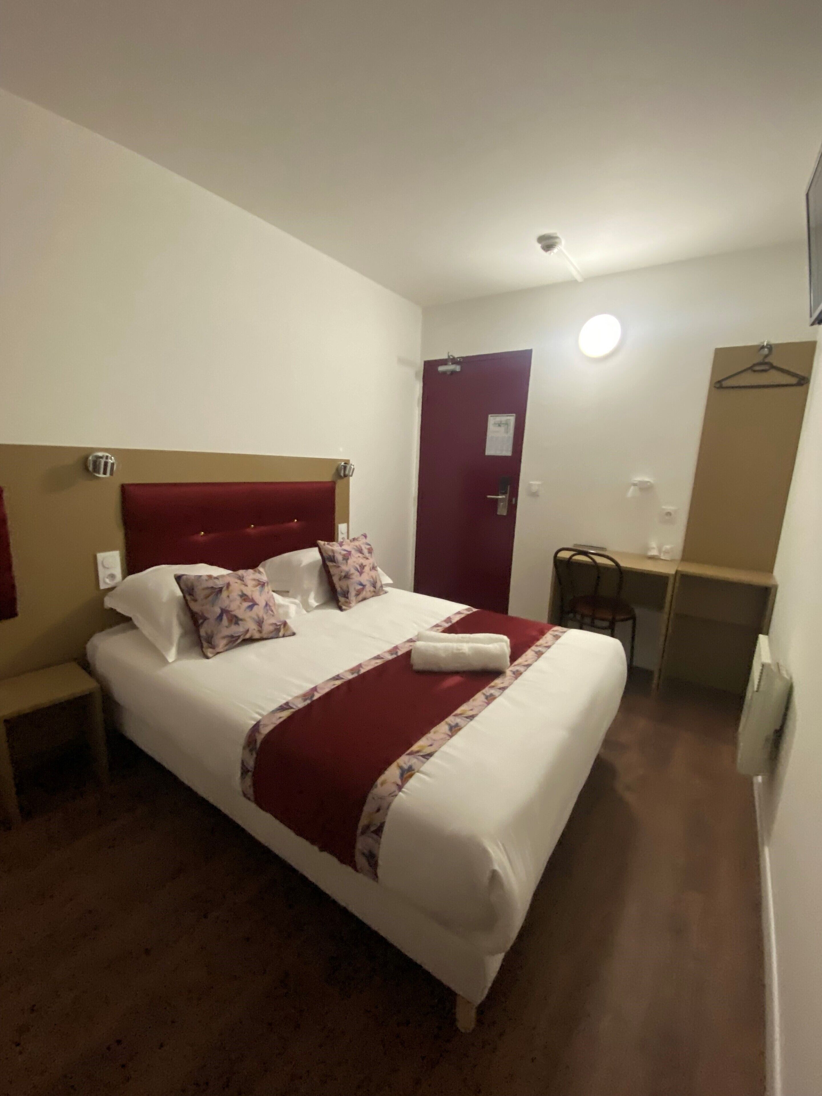 Habitació d'hotel amb un llit gran, un escriptori i una cadira.