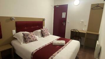Habitació d'hotel amb un llit gran, un escriptori i una cadira.