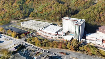 A multi-story building with a flat roof, surrounded by parking areas and trees.