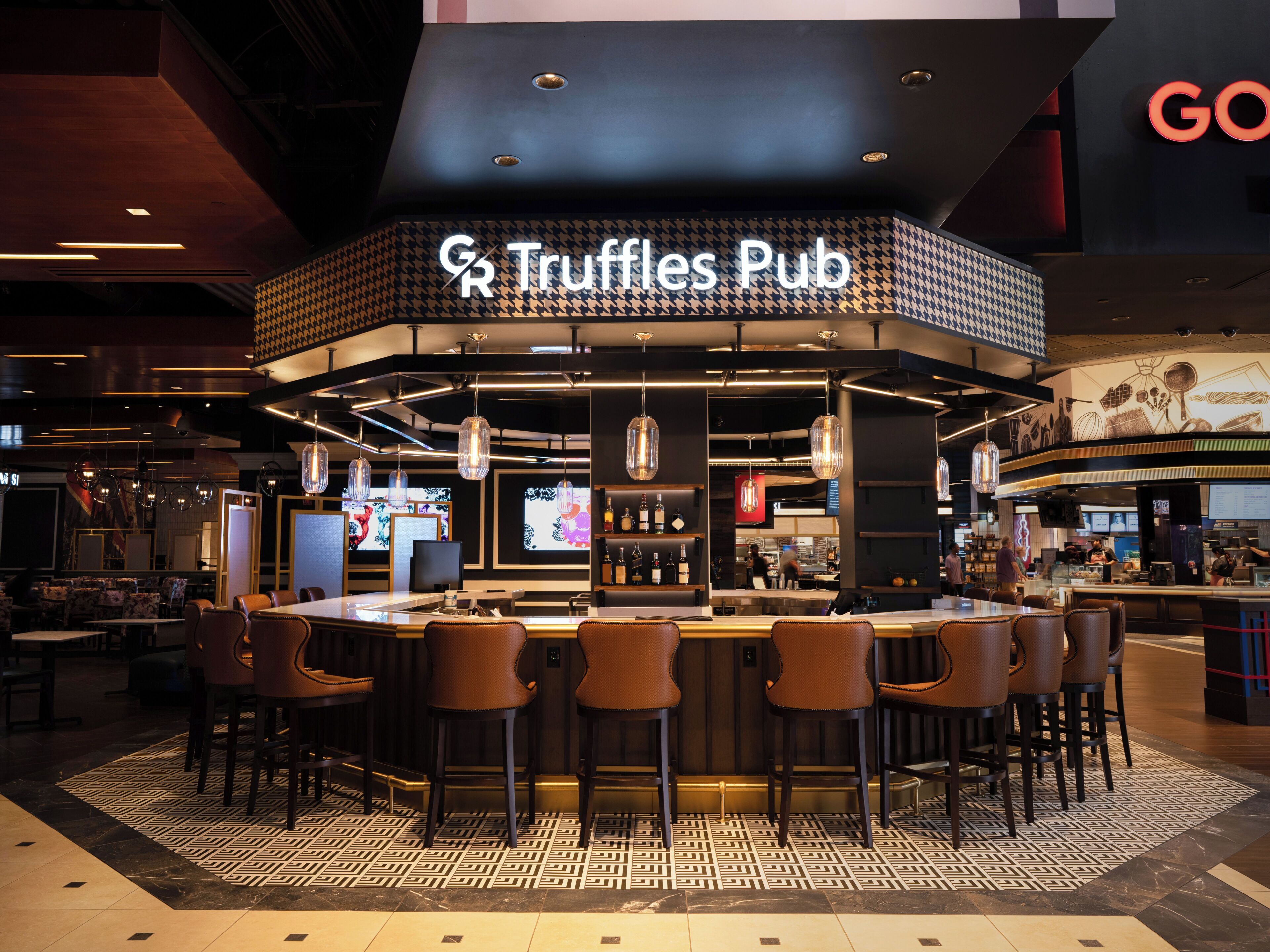 A bar area with a sign reading 'Truffles Pub' and multiple seating options.