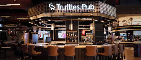 A bar area with a sign reading 'Truffles Pub' and multiple seating options.