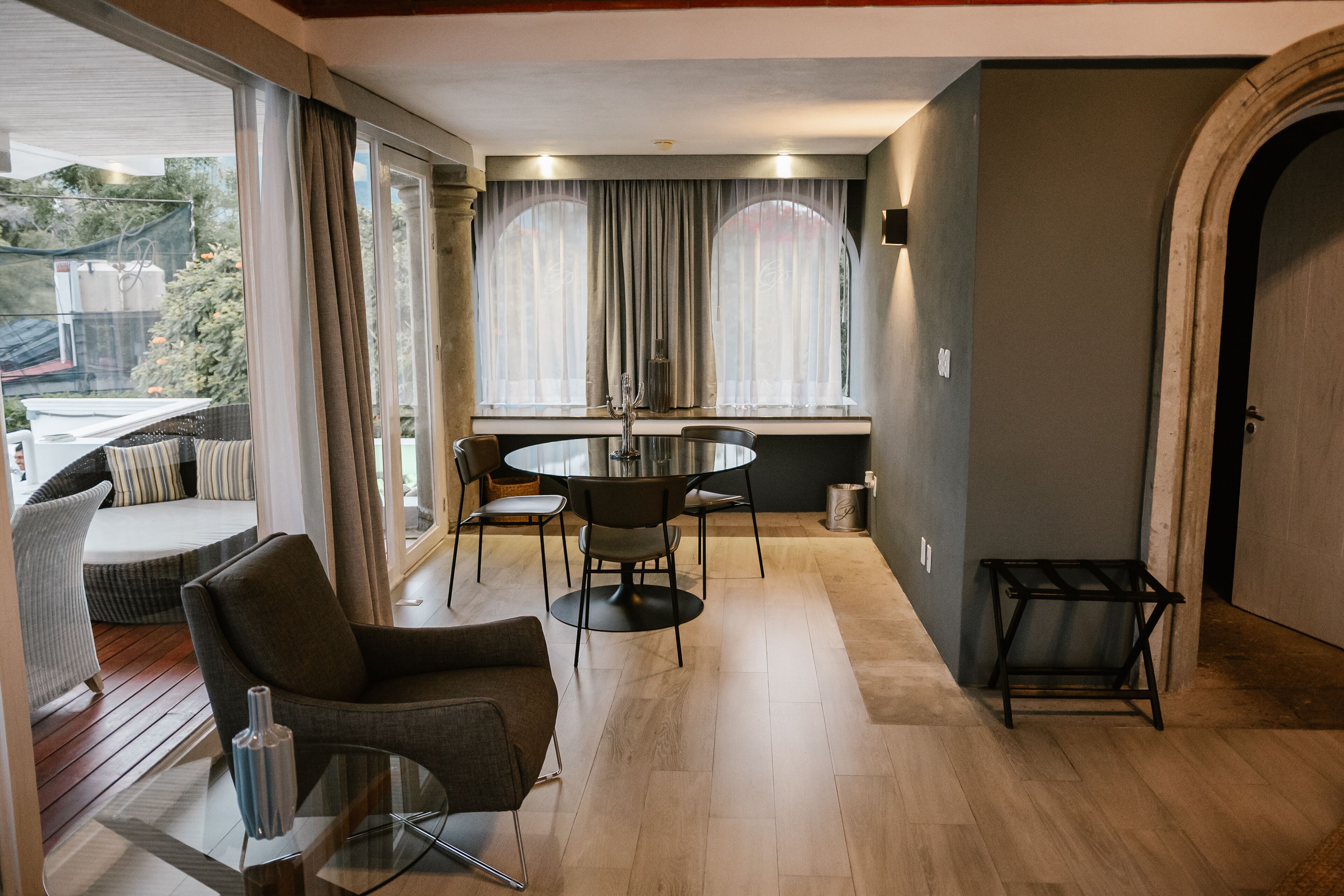 Una sala de estar moderna con una mesa redonda, dos sillones y un sofá.