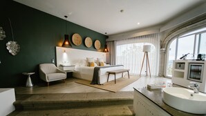 A modern bedroom with a bed, bedside table, lamp, and a view of the outdoors through large windows. - Hotel Boutique de Cantera y Plata (Taxco)