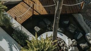 A wooden deck with a rope barrier, surrounded by rocks and plants. - Hotel Boutique de Cantera y Plata (Taxco)