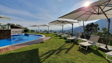 Una piscina al aire libre, tumbonas