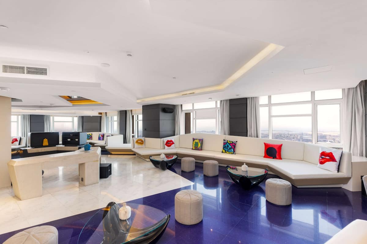 Un'ampia zona giorno dal design moderno, con un divano spazioso, un tavolino da caffè e un tavolo con piano in vetro.