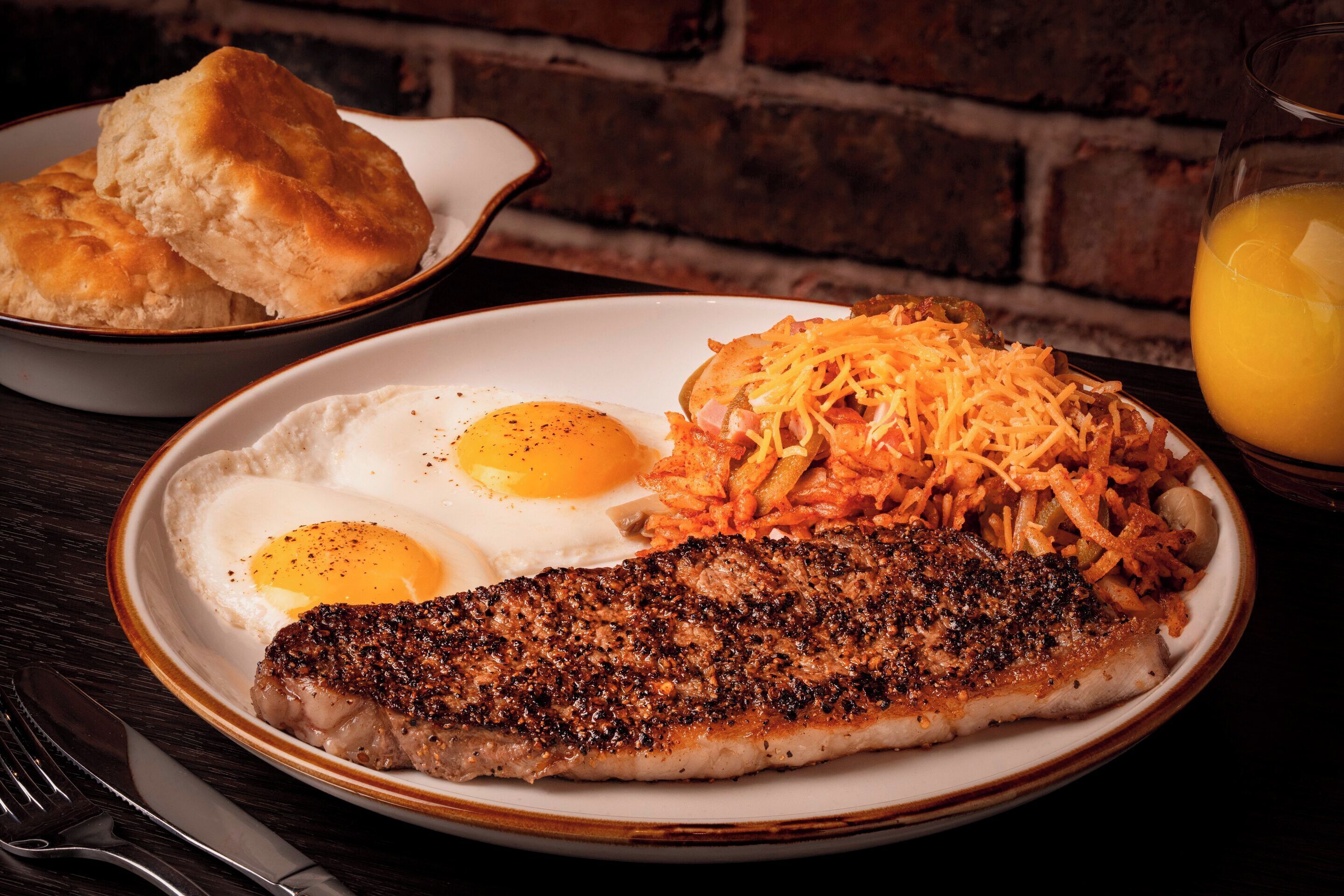 A plate with a steak, eggs, and hash browns.
