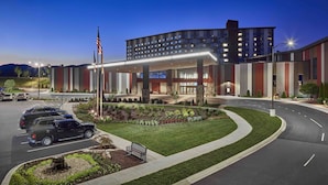 A modern hotel with a curved driveway, a parking area, and a well-maintained garden. - Harrah's Cherokee Valley River Hotel & Casino – A Caesars Rewards Destination (Murphy)