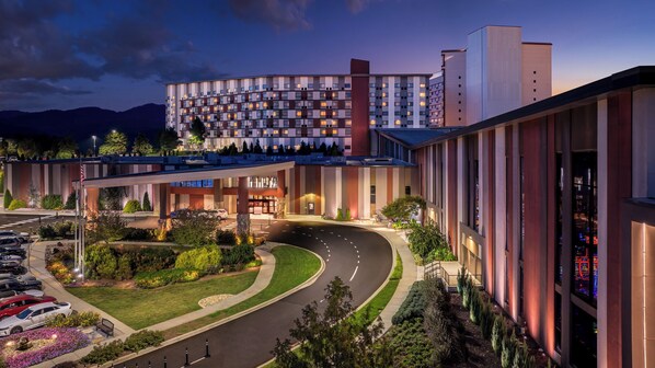 Ein modernes Hotel mit Innenhof, überdachter Eingangszone und Parkplatz.