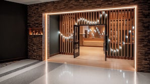A modern spa entrance with a wooden slat partition, a reception desk, and a sign reading 'SPA'. - Harrah's Cherokee Valley River Hotel & Casino – A Caesars Rewards Destination (Murphy)
