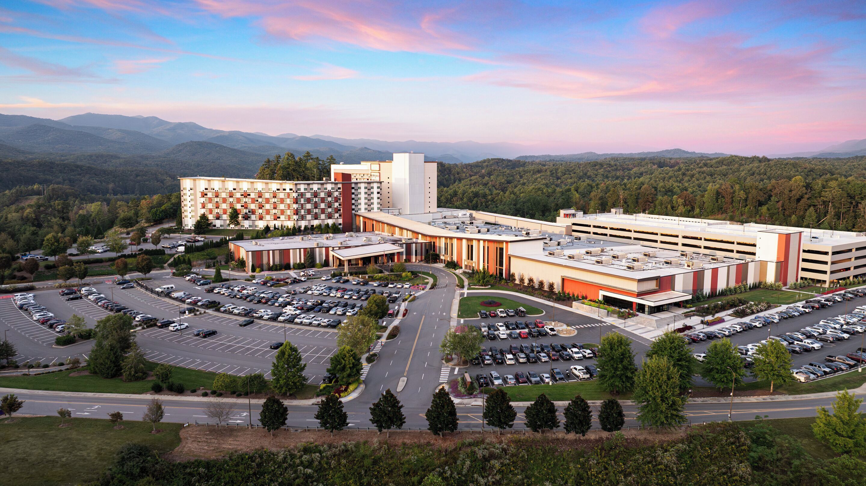 Un hôtel à plusieurs étages doté d’un parking et offrant une vue sur les montagnes environnantes.