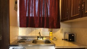 Una cocina con estufa, pileta y alacenas.