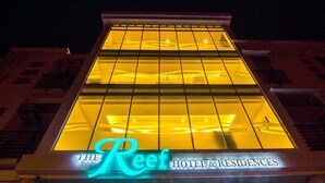 A hotel sign with the name "The Reef Hotel & Residences" illuminated at night. - The Reef Hotel and Residences (Olongapo)