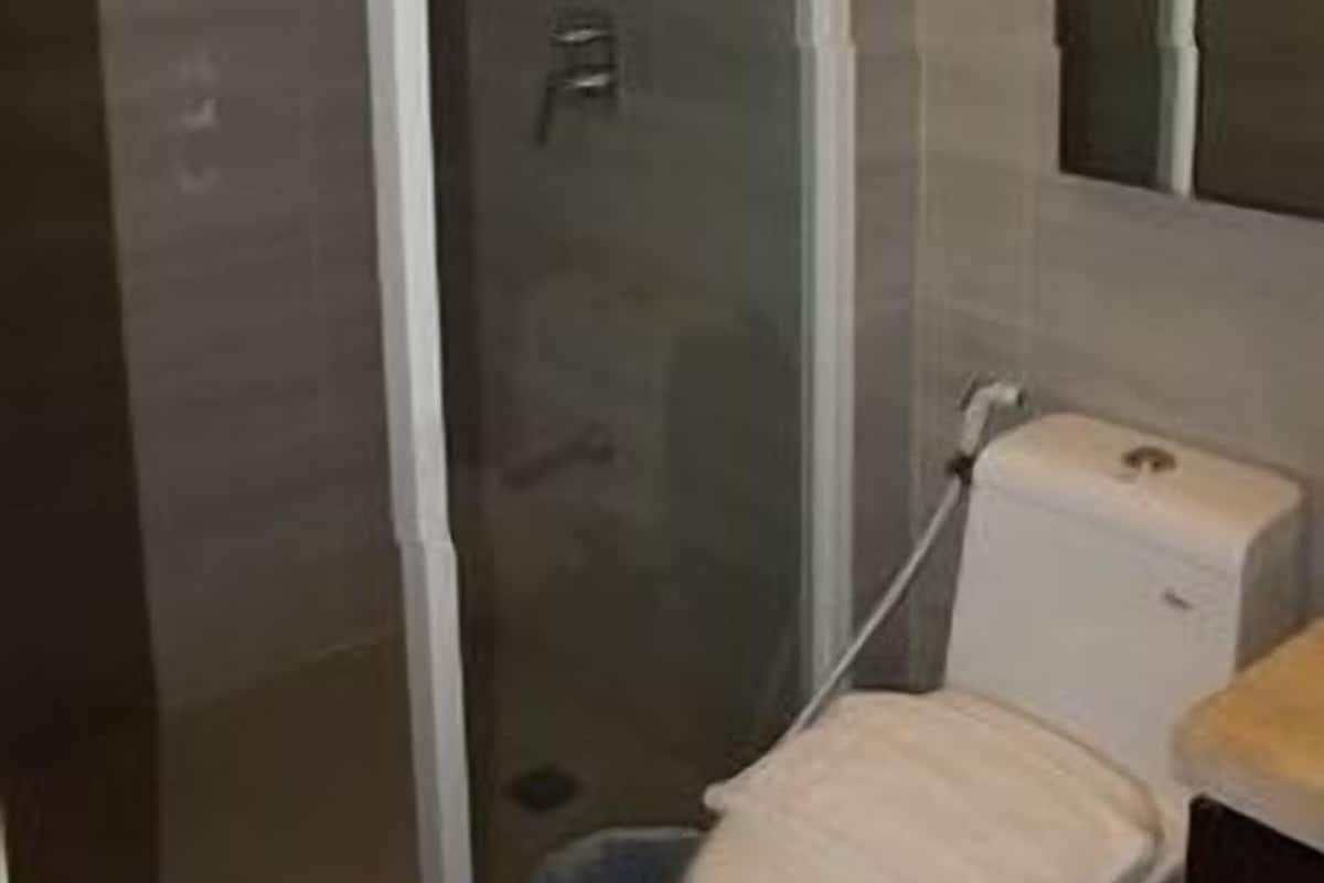 A bathroom with a glass shower enclosure, a toilet, and a sink.
