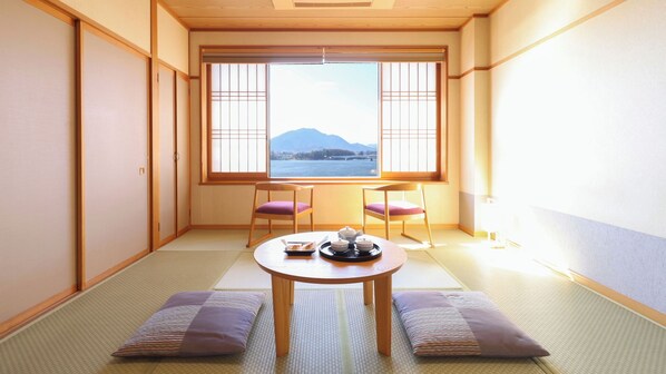 A traditional Japanese room with tatami flooring, a low table with tea set, two chairs, and a view of a mountain through a shoji screen. - Fujikawaguchiko Onsen Hotel Asafuji (Fujikawaguchiko)