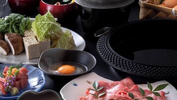 Variedad de alimentos, como sashimi, tofu y verduras, sobre una mesa.