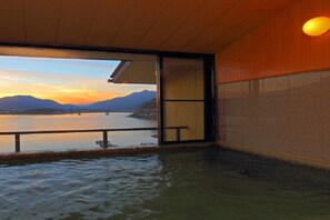 A room with a view of a body of water and mountains during sunset. - Fujikawaguchiko Onsen Hotel Asafuji (Fujikawaguchiko)