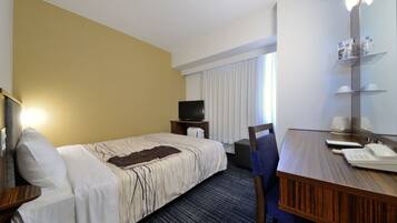 Una habitación de hotel con cama, escritorio, silla, televisor y ventana con cortinas.