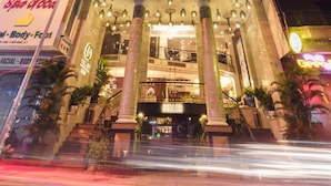 The exterior of the Roseland Corp Hotel at night, featuring a prominent sign, multiple floors, and a large clock. - Roseland Corp Hotel (Ho Chi Minh City)