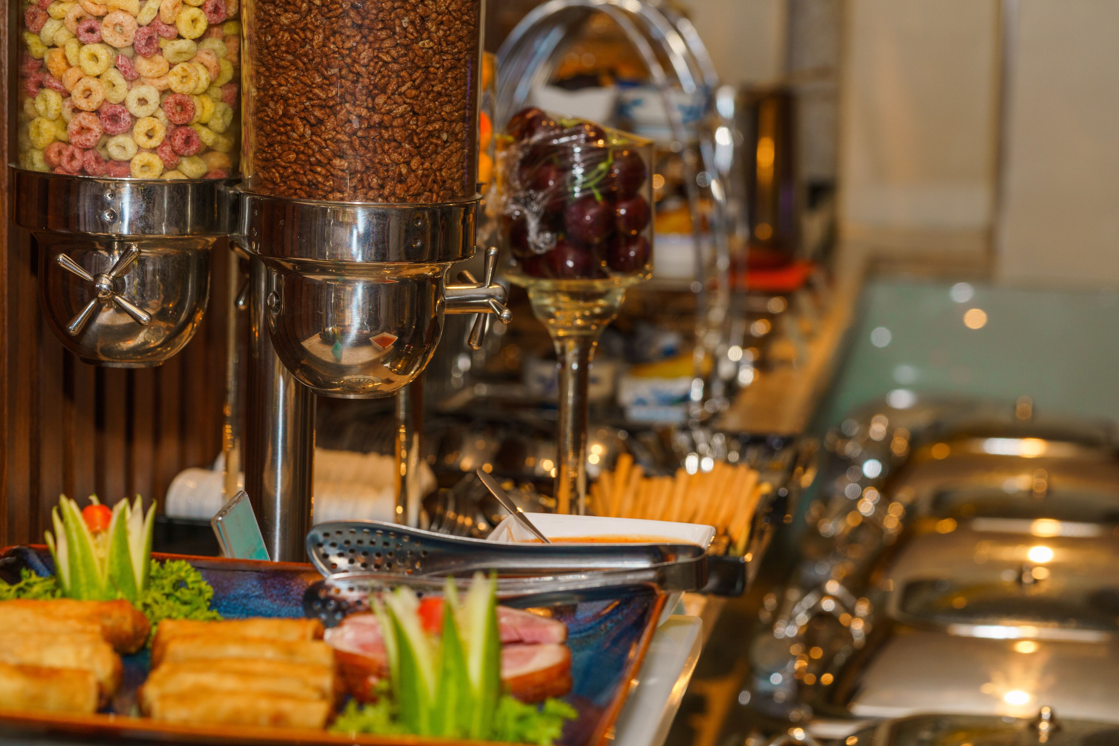 A buffet setup with various food items and utensils.