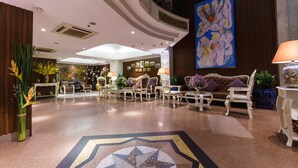 A spacious lobby with a high ceiling, elegant furniture, and a large abstract painting. - Roseland Corp Hotel (Ho Chi Minh City)