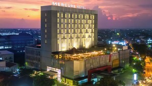 Un hotel moderno con un letrero llamativo, varios pisos y una fachada bien iluminada.