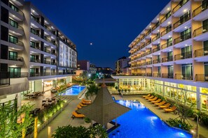 Una piscina al aire libre, sombrillas, tumbonas