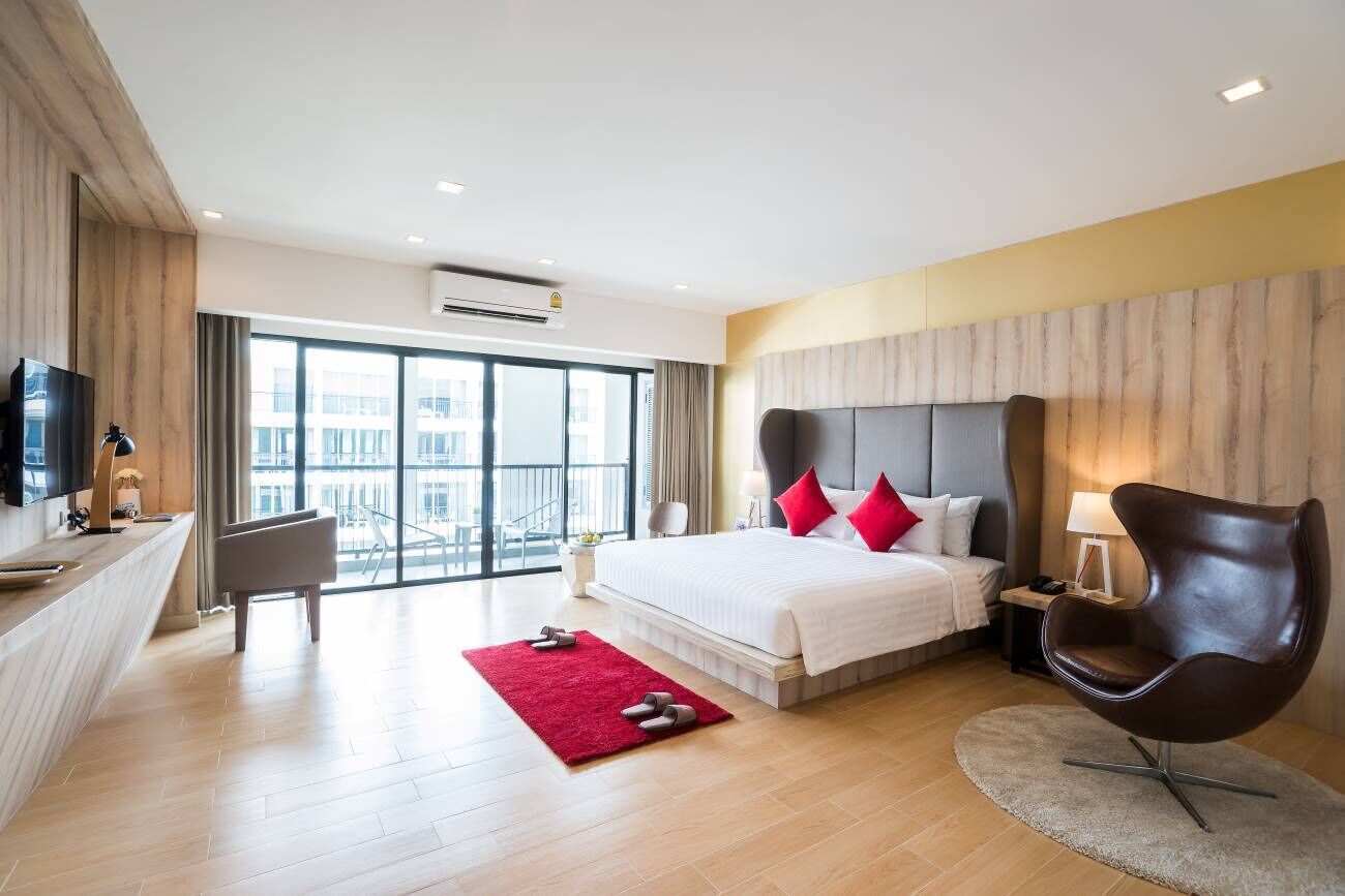 Habitación de hotel moderna con una cama grande, televisión, escritorio y vistas a la ciudad.