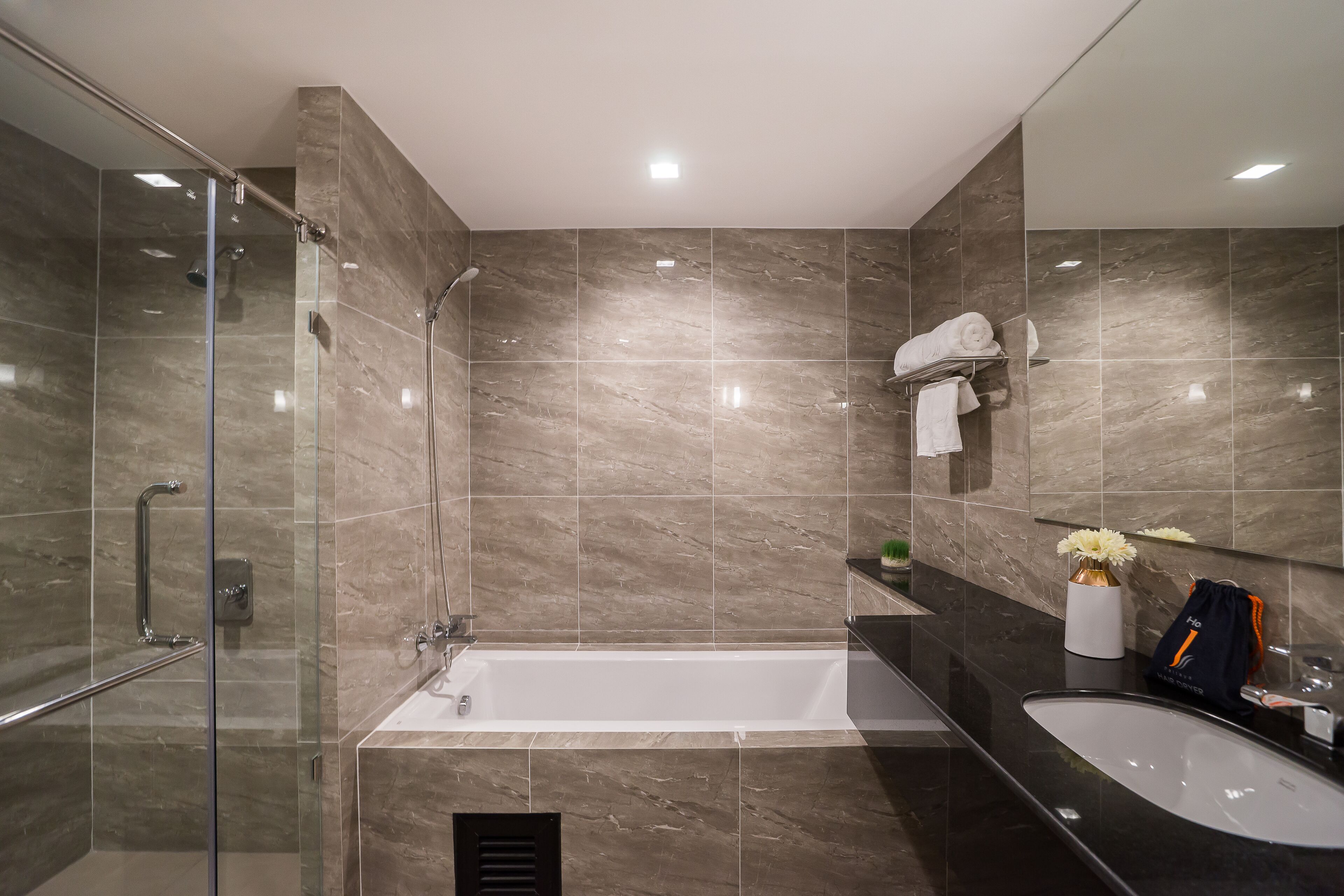 A modern bathroom with a glass shower enclosure, a freestanding bathtub, and a vanity with a sink.