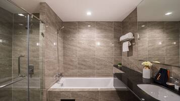 A modern bathroom with a glass shower enclosure, a freestanding bathtub, and a vanity with a sink.