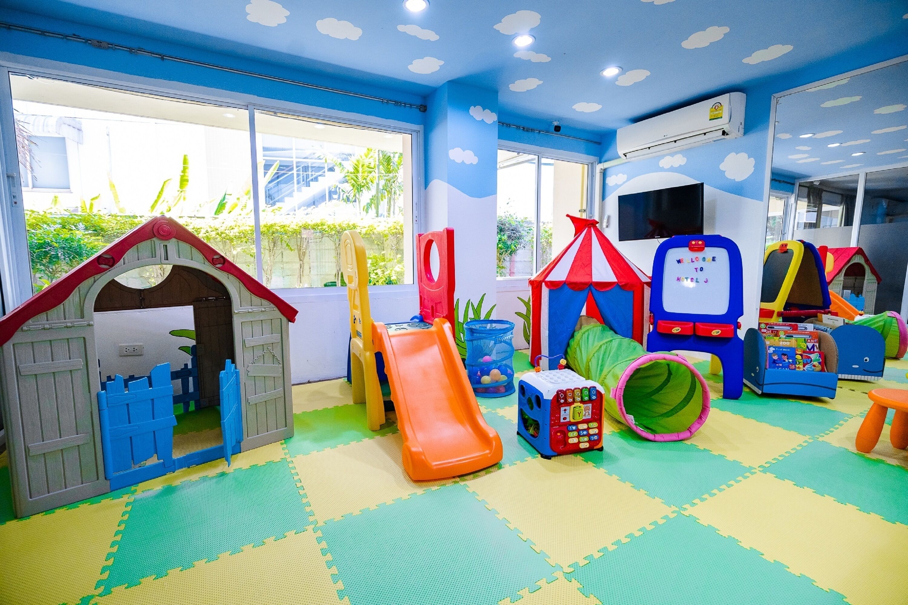 A children's play area with a playhouse, slide, and various toys.