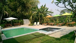 Una piscina al aire libre, sombrillas, tumbonas