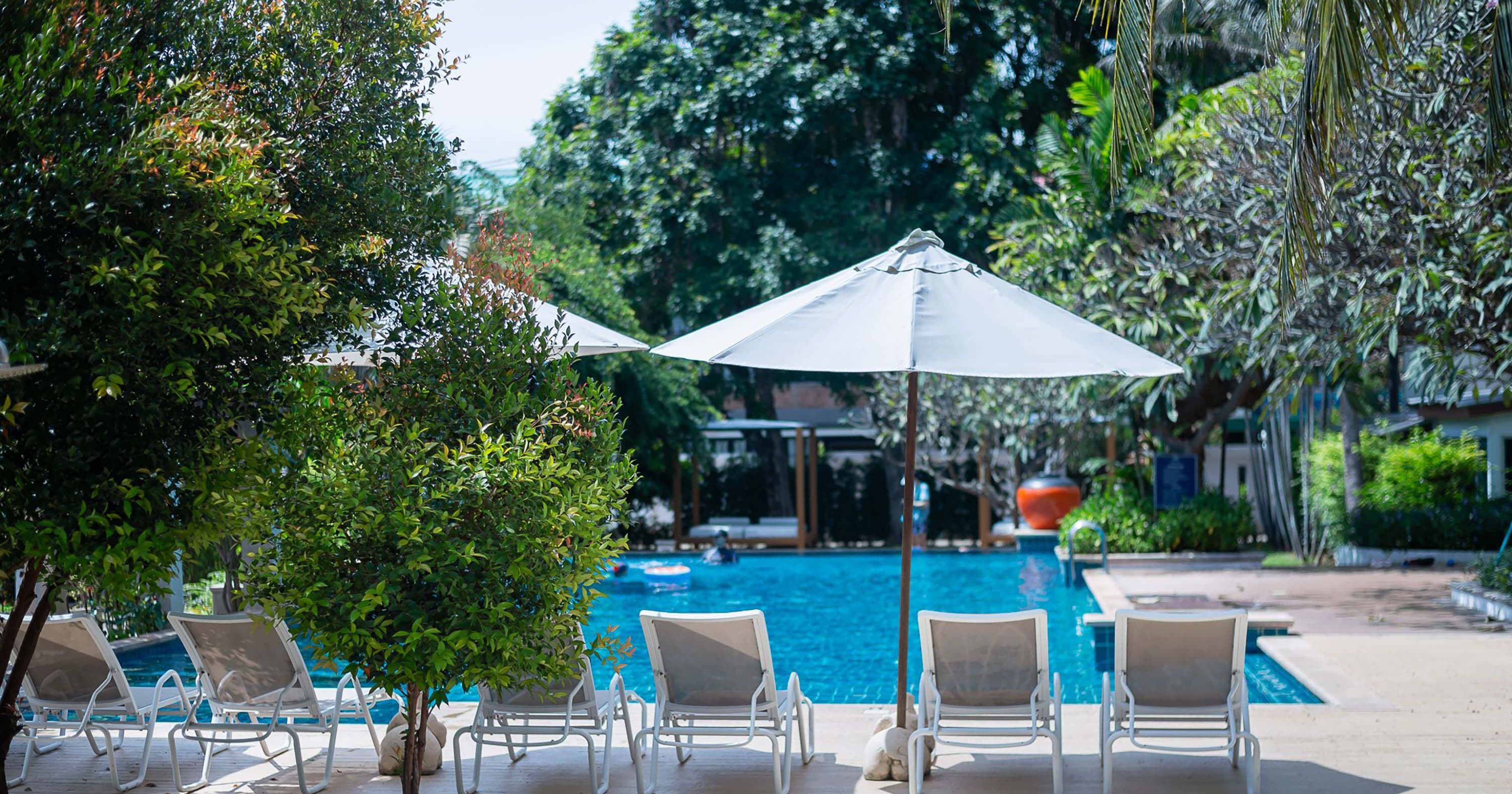Un espace aménagé au bord de la piscine, avec des chaises longues et un parasol.
