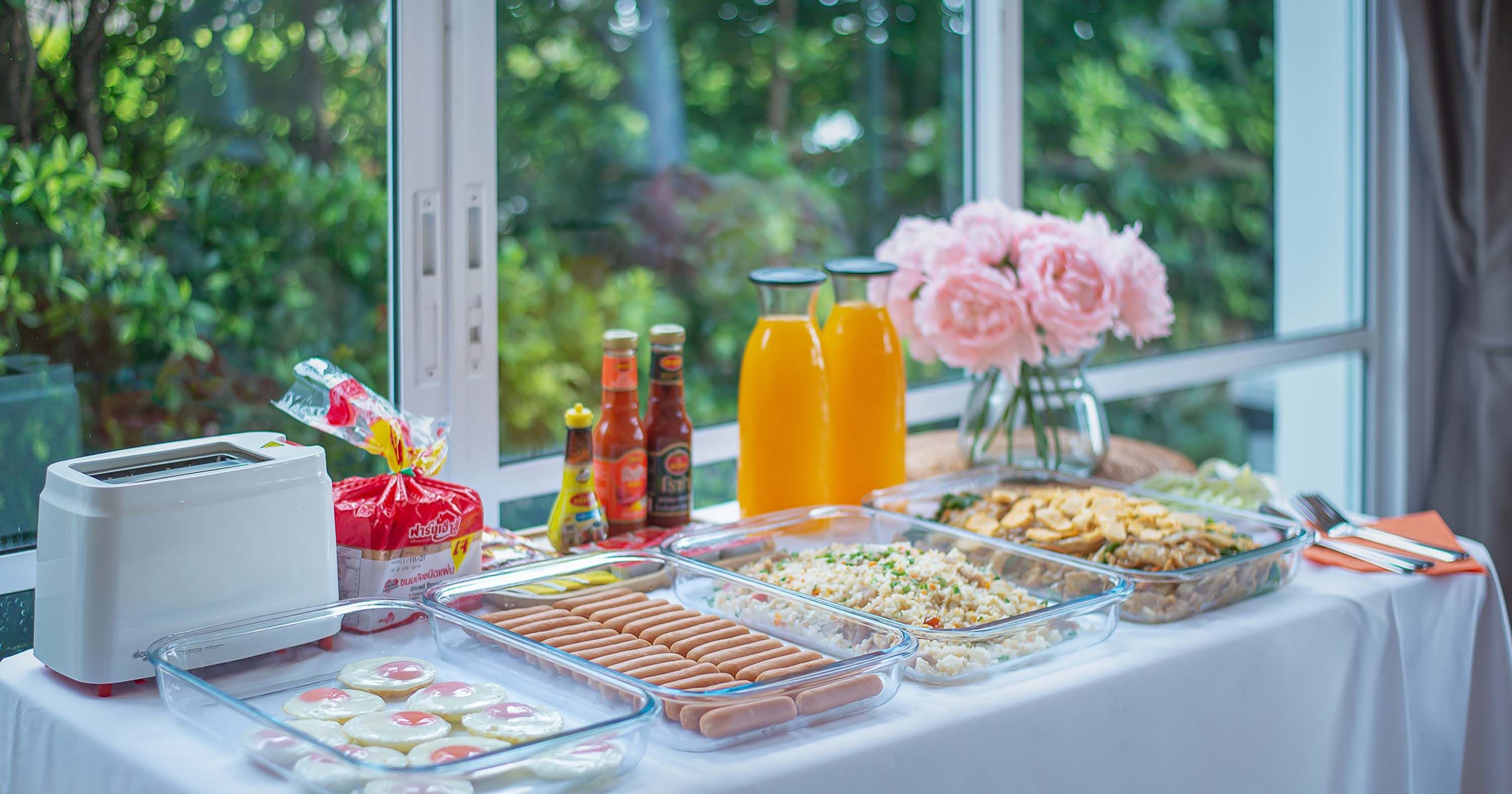 A buffet table with various food items, condiments, and a toaster.