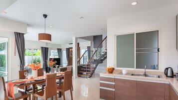 A modern kitchen with a large window, a built-in oven, and a stainless steel sink.
