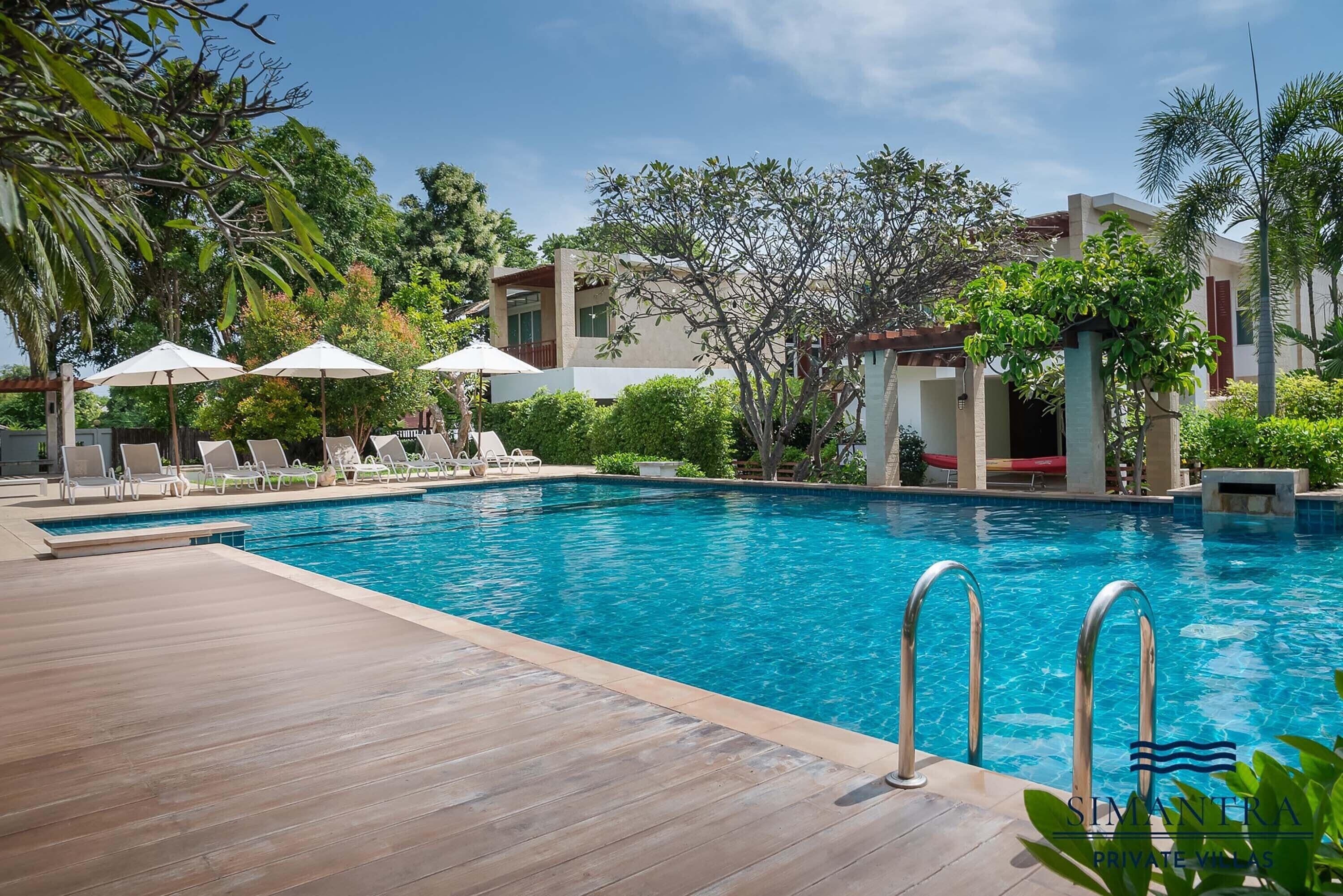 Una piscina al aire libre, camas de piscina gratis, sombrillas
